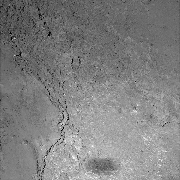 Imagem feita a partir da sonda Rosetta mostra região do cometa Comet 67P/Churyumov-Gerasimenko; mancha escura na parte inferior da imagem é sompra de sonda (Foto:  ESA/Rosetta/MPS for OSIRIS Team MPS/UPD/LAM/IAA/SSO/INTA/UPM/DASP/IDA)