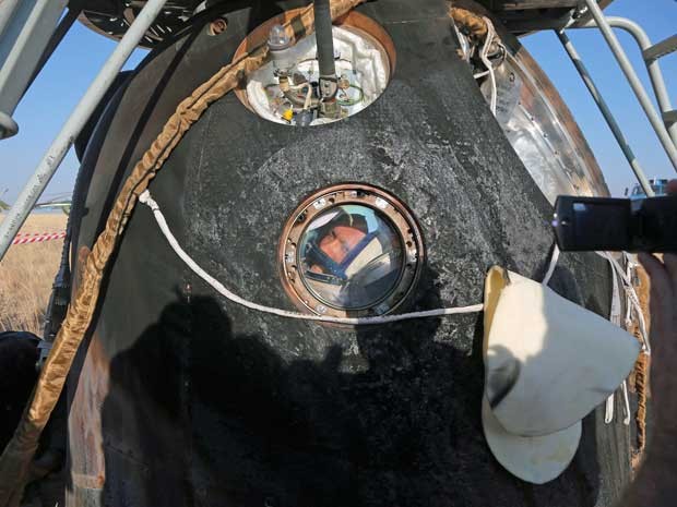 Cosmonauta russo Oleg Artemiev olha para fora da cápsula de descida da Soyuz TMA-12M , que pousou no Cazaquistão. (Foto: Maxim Shipenkov / Pool / AP Photo)