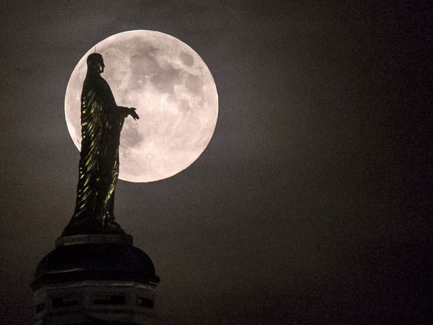 Lua vista sobre a estátua da Virgem Maria no topo da Universidade de Notre Dame, nos Estados Unidos (Foto: Robert Franklin/AP)
