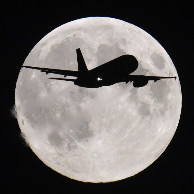 Silhueta de avião pode ser vista passado em frente à Lua em Londres nesta segunda-feira (8) (Foto: Toby Melville/Reuters)
