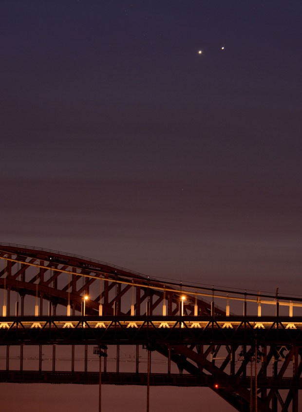 Aproximação dos planetas no céu foi fotografada perto das pontes de Hell Gate (atrás) e Robert F. Kennedy (frente), em Nova York (Foto: Stan Honda/AFP)