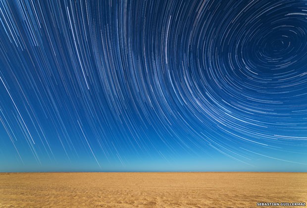 O argentino Sebastián Guillermaz também produziu esta fotografia das luzes das estrelas sob a praia em Mar de Ajo, em Buenos Aires. O fotógrafo utilizou várias imagens para criar um efeito de passagem do tempo (Foto: Sebastián Gutierrez/BBC)
