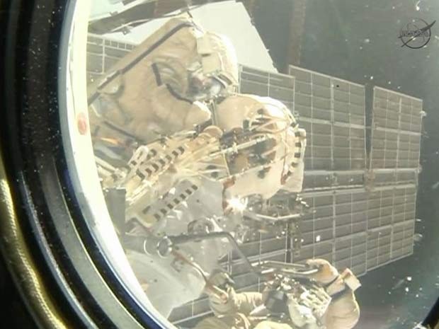 Uma câmera dentro da Estação Espacial Internacional captou caminhada espacial realizada nesta sexta-feira (27) (Foto: NASA TV)