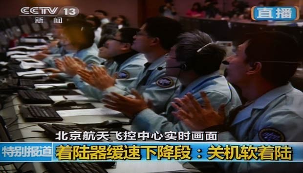Em Pequim, cientistas chineses celebram o sucesso do pouso na Lua (Foto: AFP/CCTV)