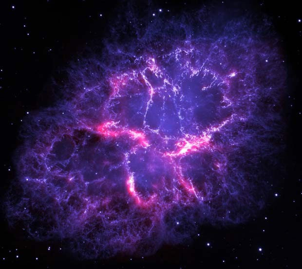 Em azul, luz ?visível? que vem da emissão de gases (energizados pela estrela neutra no centro) na Nebulosa Caranguejo vista pelo telescópio espacial Hubble, da Nasa. Em vermelho, luz infravermelha proveniente de poeira fria e gases vista pelo Observatório Espacial Herschel, da ESA (Foto: NASA, ESA, Alison Loll &amp; Jeff Hester (University of Arizona))