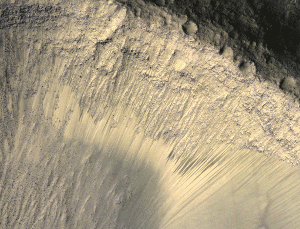 Imagens da alta resolução mostram o aparecimento de manchas escuras sobre inclinação de Marte com a mudança de estações