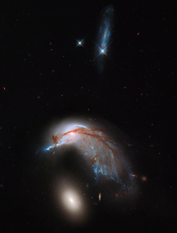 Imagem do telescópio Hubble mostra interação de galáxias conhecida como Arp 142, que lembra pinguim cuidando de ovo (Foto: AFP/NASA-ESA Hubble Heritage )