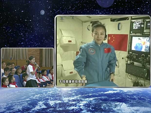 Jovem aluna faz pergunta através de videoconferência para a astronauta e professora Wang Yaping. (Foto: CCTV / AP Photo)