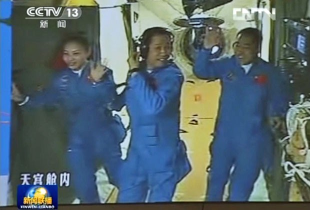 Outa imagem da CCTV mostra os astronautas Wang Yaping, Nie Haisheng e Zhang Xiaoguang já dentro do Tiangong-1. Wang é a segunda mulher chinesa a ser mandada ao espaço (Foto: AFP/CCTV)