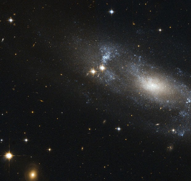 Imagem divulgada pela agência espacial americana, a Nasa, mostra a galáxia espiral ESO 499-G37. Pelo ângulo captado pelo telescópio Hubble, é possível ver a formação em espiral da galáxia (formada por pontos azuis). Segundo a Nasa, o sistema estelar está localizado a 59 milhões de anos-luz do Sol. (Foto: Nasa/Reuters)