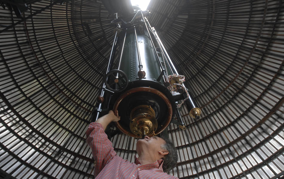O chefe da Divisão de Atividades Educacionais do observatório, Carlos Henrique Veiga, posa com o maior telescópio do país, que completa 90 anos. A luneta foi adquirida em 1911, mas chegou ao Brasil somente em 1921.