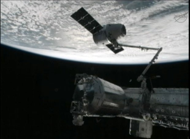 A imagem mostra um braço robótico a Estação Espacial "capturando" a cápsula Dragon (Foto: Nasa/AP)