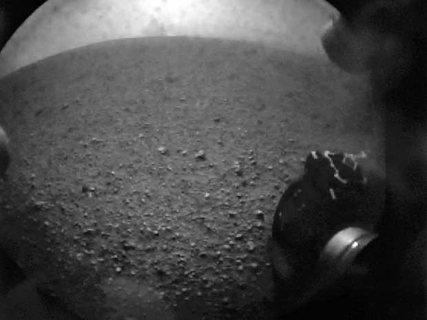 Primeira imagem feita pelo Curiosity em Marte mostra a roda do Jipe na superfície do planeta. (Foto: Reprodução / Nasa TV / Reuters)