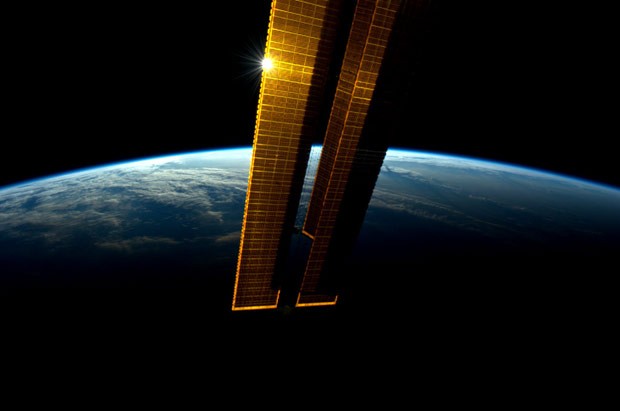 Sol reflete nos painéis solares da Estação Espacial Internacional durante o amanhecer. A foto foi tomada pelo astronauta Andre Kuipers em 8 de junho e divulgada nesta quarta (13) (Foto: Andre Kuipers/Nasa/AP)