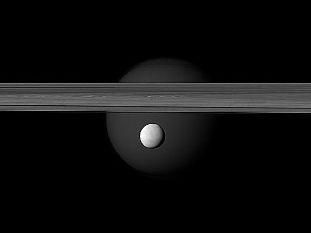 Fotografia mostra a lua Encélado à frente da lua Titã. Entre elas aparecem os famosos aneis de Saturno. A fotografia foi feita pela sonda espacial Cassini em 12 de março e divulgada nesta quinta-feira (10) pela Nasa. (Foto: NASA/JPL-Caltech/Space Science Institute)