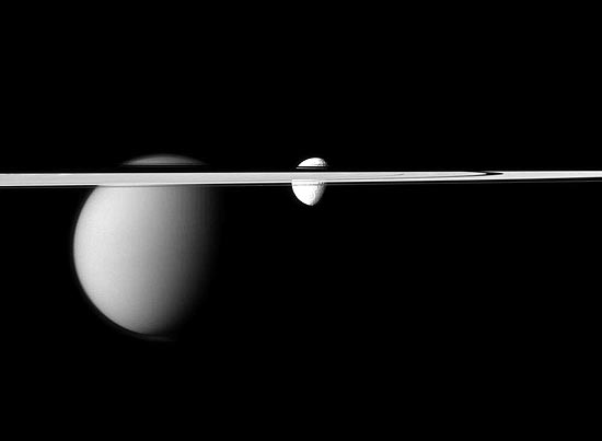 Os aneis de Saturno e as luas Titã (esq.) e Tetis (dir.) foram fotografadas pela sonda americana Cassini