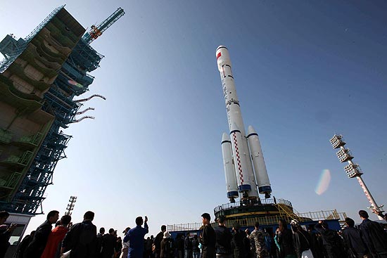Turistas observam o foguete Longa Marcha 2F, que transporta o primeiro módulo da estação chinesa