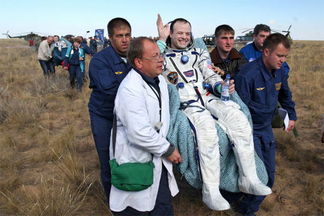 Astronauta americano Rolamd Garan é carregado após aterrissagem da nave russa Soyuz nas estepes do Cazaquistão