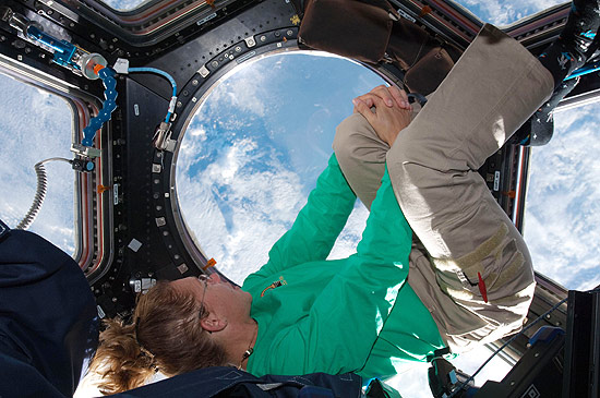 A astronauta Sandy Magnus em janela panorâmica da ISS; retorno do Atlantis está marcada para as 6h56