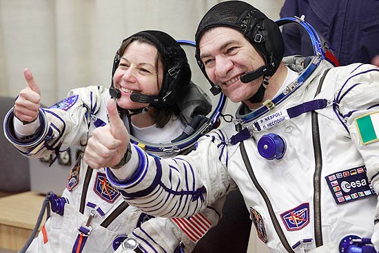 A partir da esq., a americana Catherine Coleman e a italiana Paolo Nespoli, da missão russa, acenam antes de voo