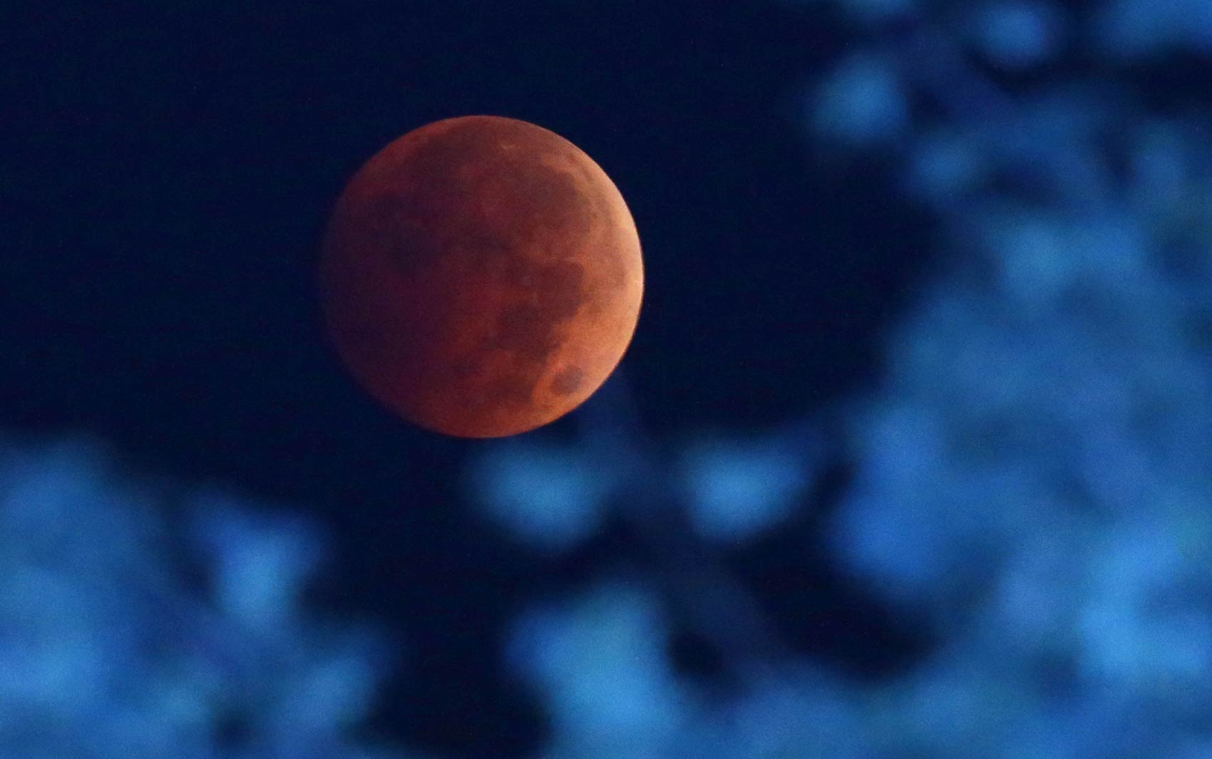 Passagem da luz do sol através da atmosfera terrestre faz com que a Lua ganhe tom avermelhado durante eclipse lunar visto de Milwaukee, nos EUA. O fenômeno é conhecido como 'Lua de sangue'