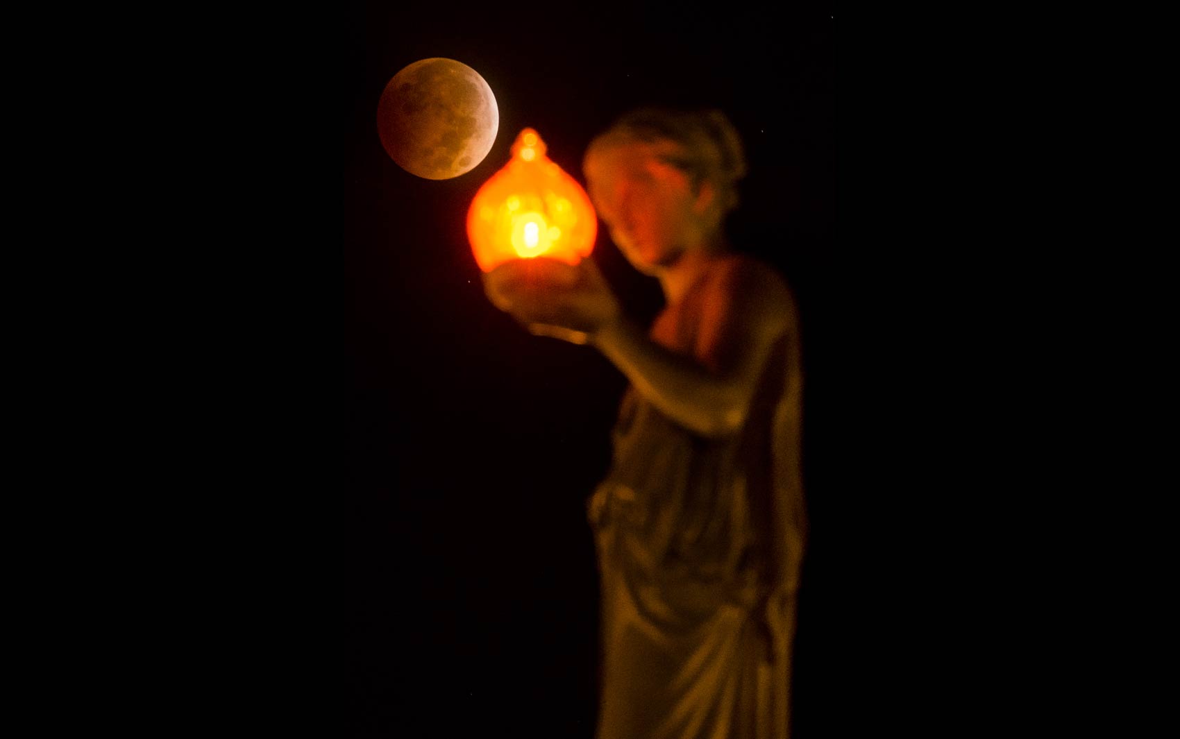 'Lua de sangue' é vista por trás de uma estátua no topo do Wheeler Town Clock em Manitou Springs, Colorado (EUA)