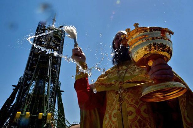 Sacerdote ortodoxo russo abençoa a nave Soyuz YMA1-13M, que deve decolar nesta quarta-feira do Cazaquistão rumo ao espaço (Foto: Kirill Kudryavtsev/AFP)