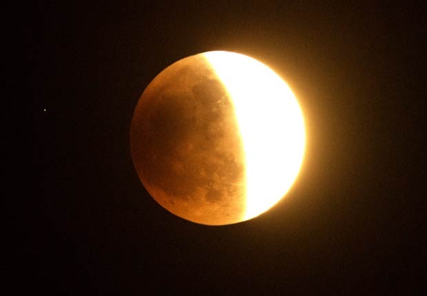 Lua é vista em meio ao eclipse lunar, observada de Los Angeles, no sul da Califórnia (Foto: Joe Klamar/AFP)