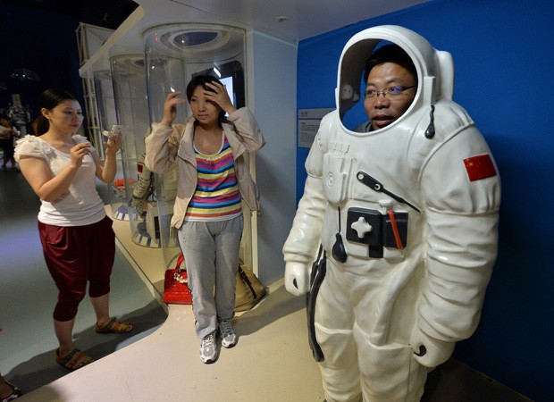 Homem 'experimenta' veste de taikonauta em uma exposição no Museu de Ciência e Tecnologia, em Pequim. (Foto: AFP Photo / Mark Ralston)