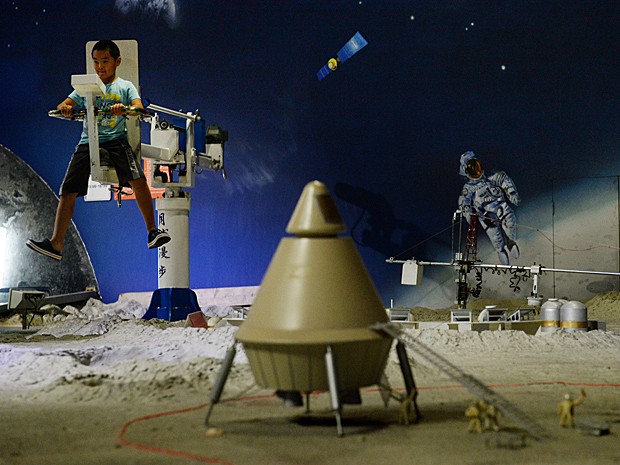 Adolescente chinês se diverte em exposição sobre o espaço no Museu de Ciência e Tecnologia de Pequim nesta sexta-feira (30) (Foto: Mark Ralston/AFP)