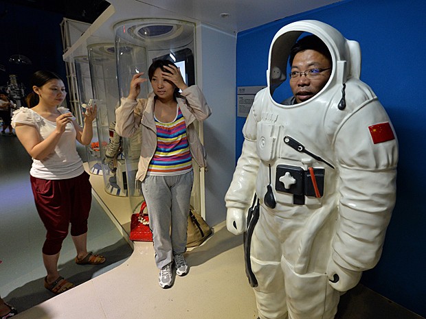 Homem veste roupa de astronauta no Museu de Ciência e Tecnologia de Pequim (Foto:  Mark Ralston/AFP)