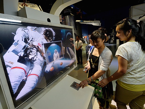 Jovens assistem a vídeo sobre espaço em museu da China (Foto: Mark Ralston/AFP)