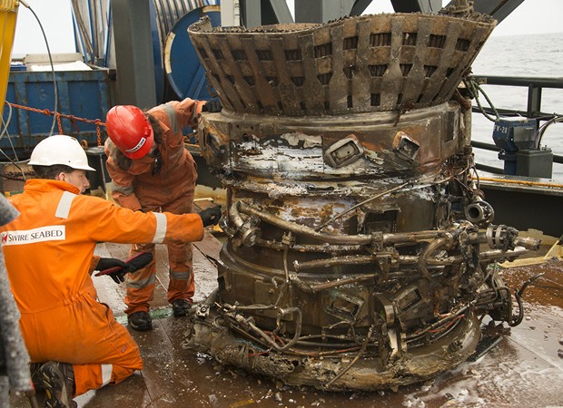 Técnicos inspecionam peça de motor da missão Apollo, resgatada a 4 km no fundo do mar (Foto: Bezos Expeditions/AP)