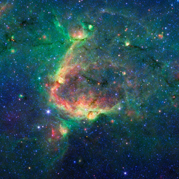 Bolha gigante esculpida na poeira espacial por estrelas de grande massa provoca a formação de bolhas menores (Foto: Nasa/JPL-Caltech/University of Wisconsin )