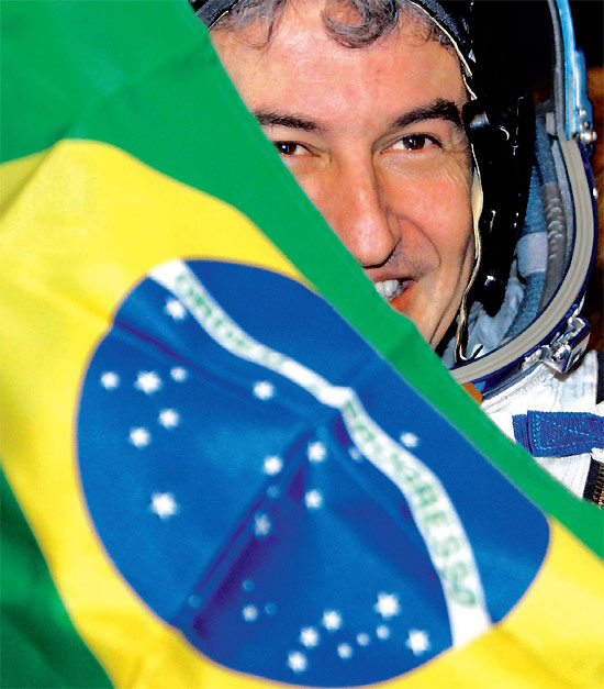 O astronauta Marcos Pontes segura a bandeira na volta à Terra